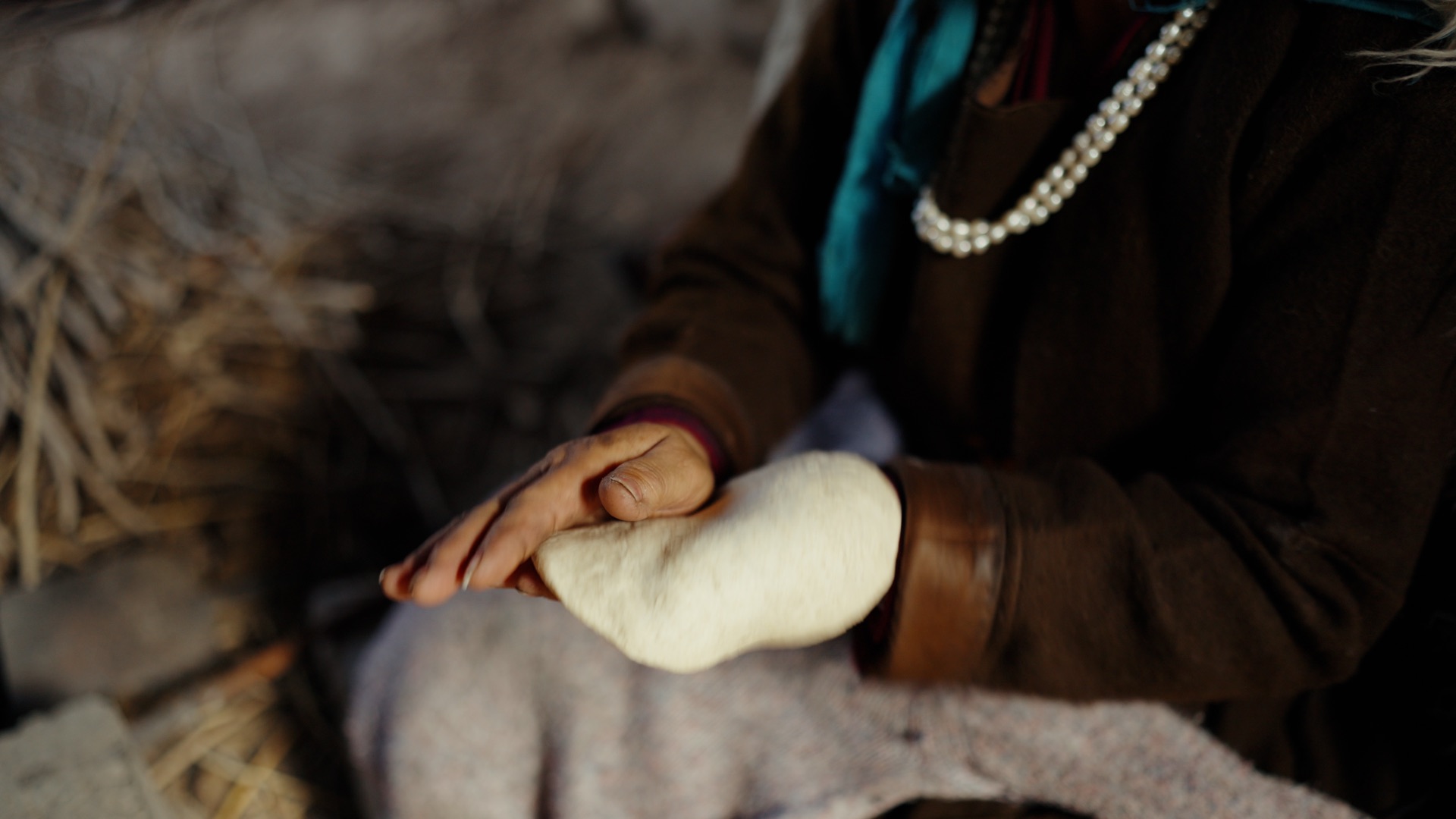 Close-up of hands spinning raw pashmina wool by hand