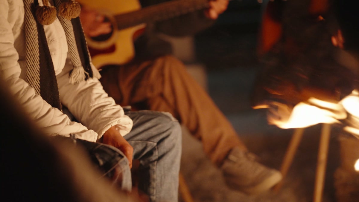 Evening campfire with guitar — the nightly bonfire ritual